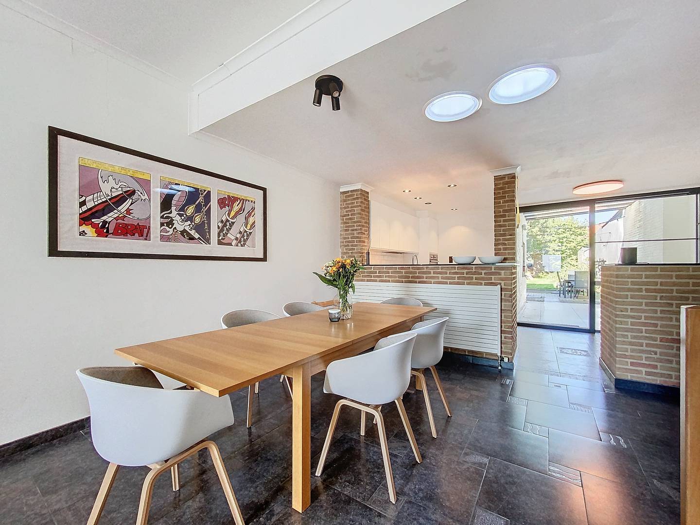 Eetkamer met doorkijk naar de keuken en de tuin