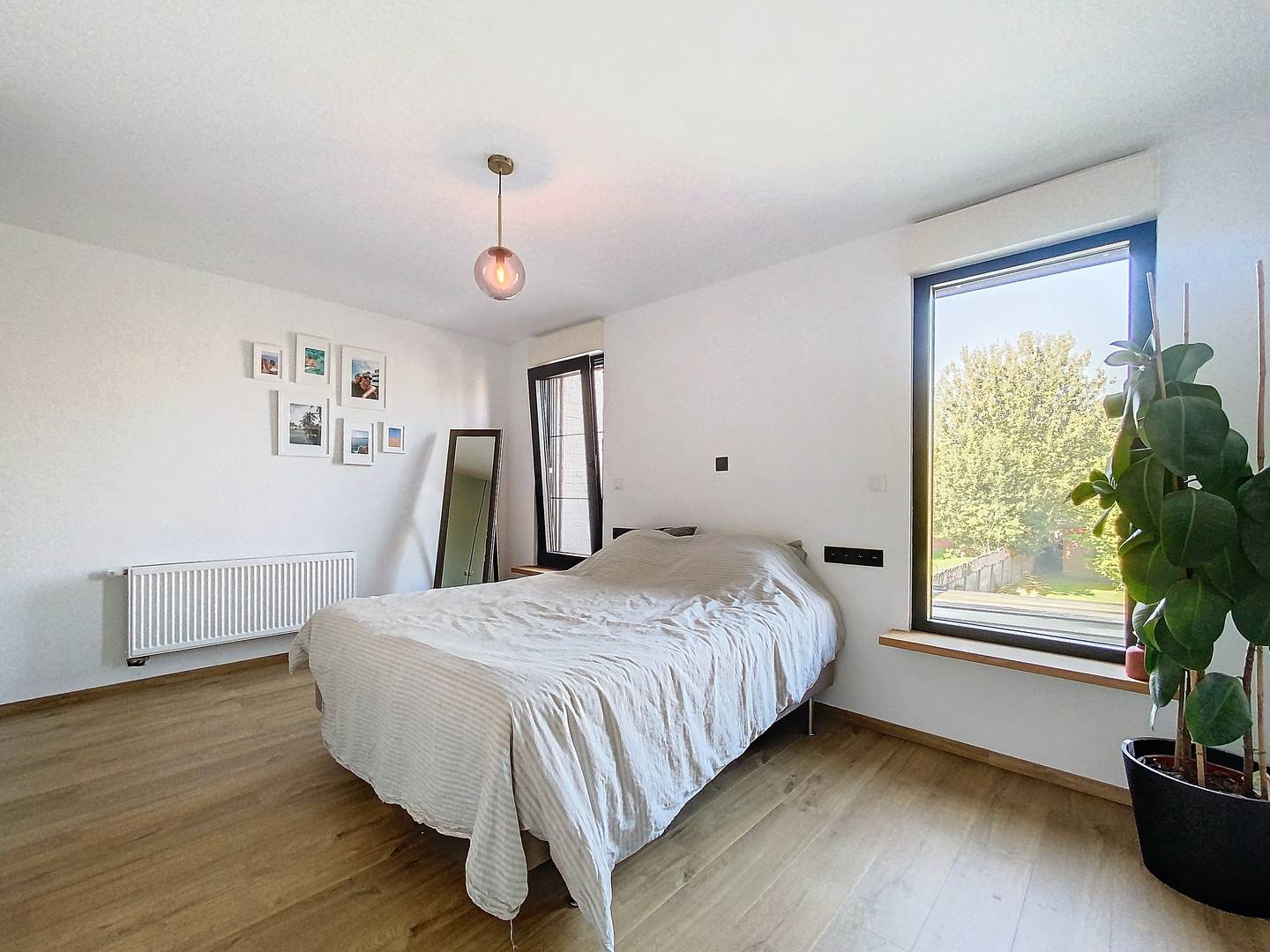 Slaapkamer met houten vloer en groot raam